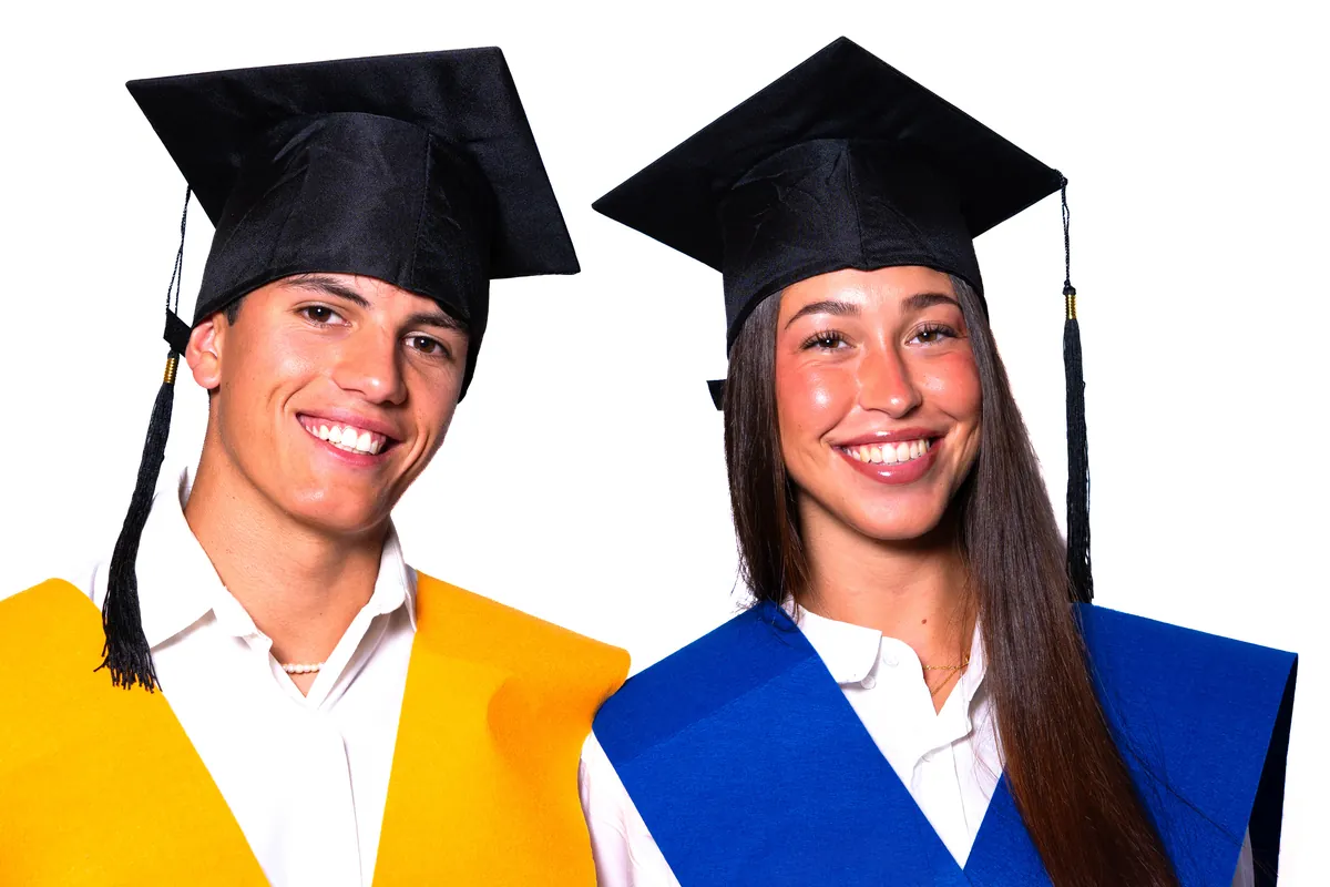 Dos estudiantes con birrete sonriendo