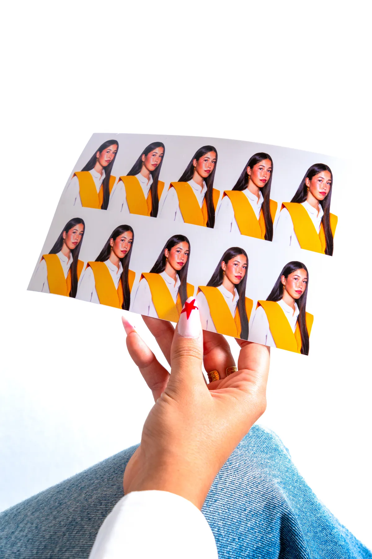 Hoja de retratos tamaño carnet en la mano